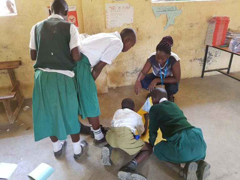 Barn i et klasserom i Kenya som jobber med livsmestringsoppgaver