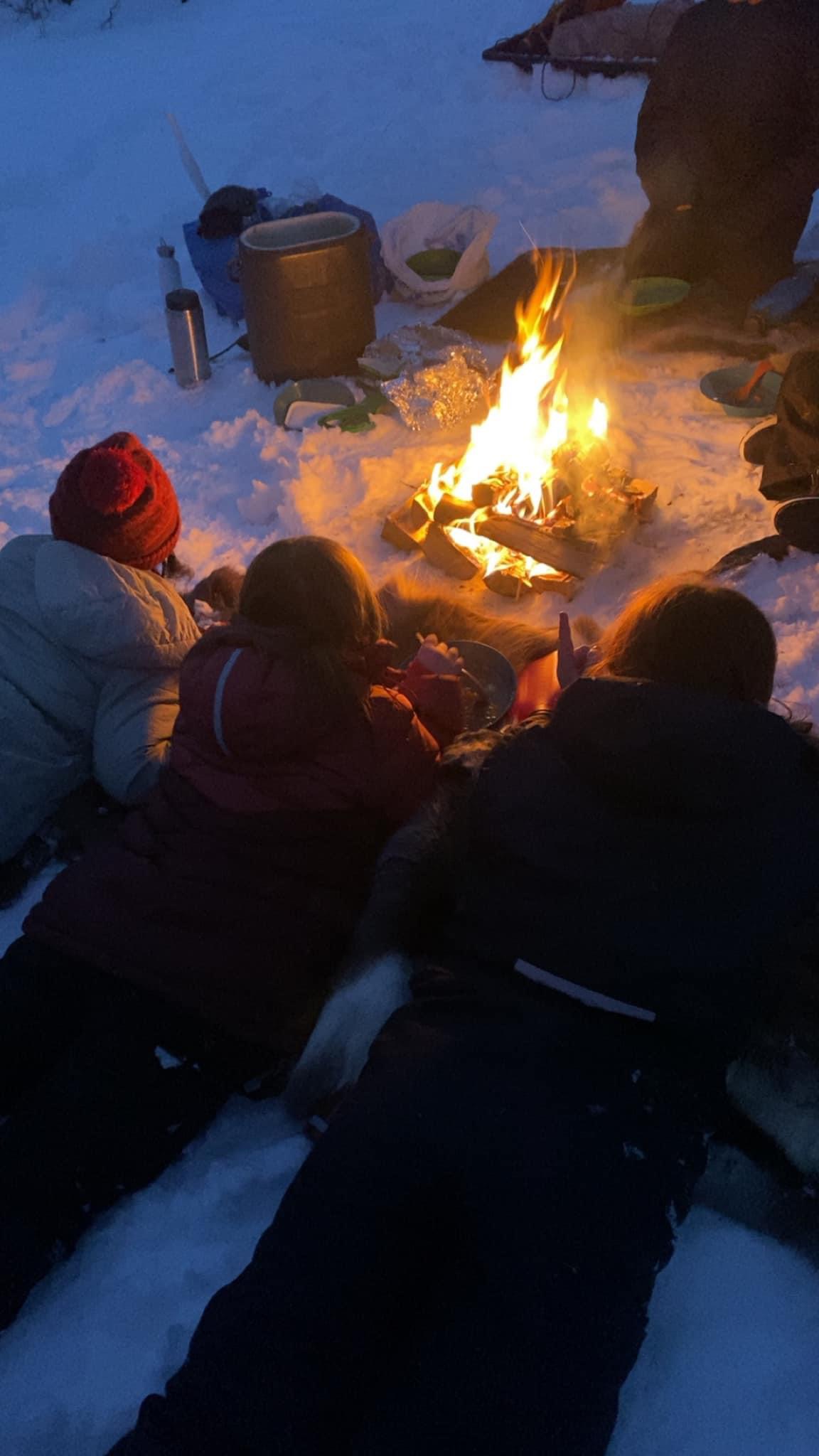 barn som sitter rundt et bål