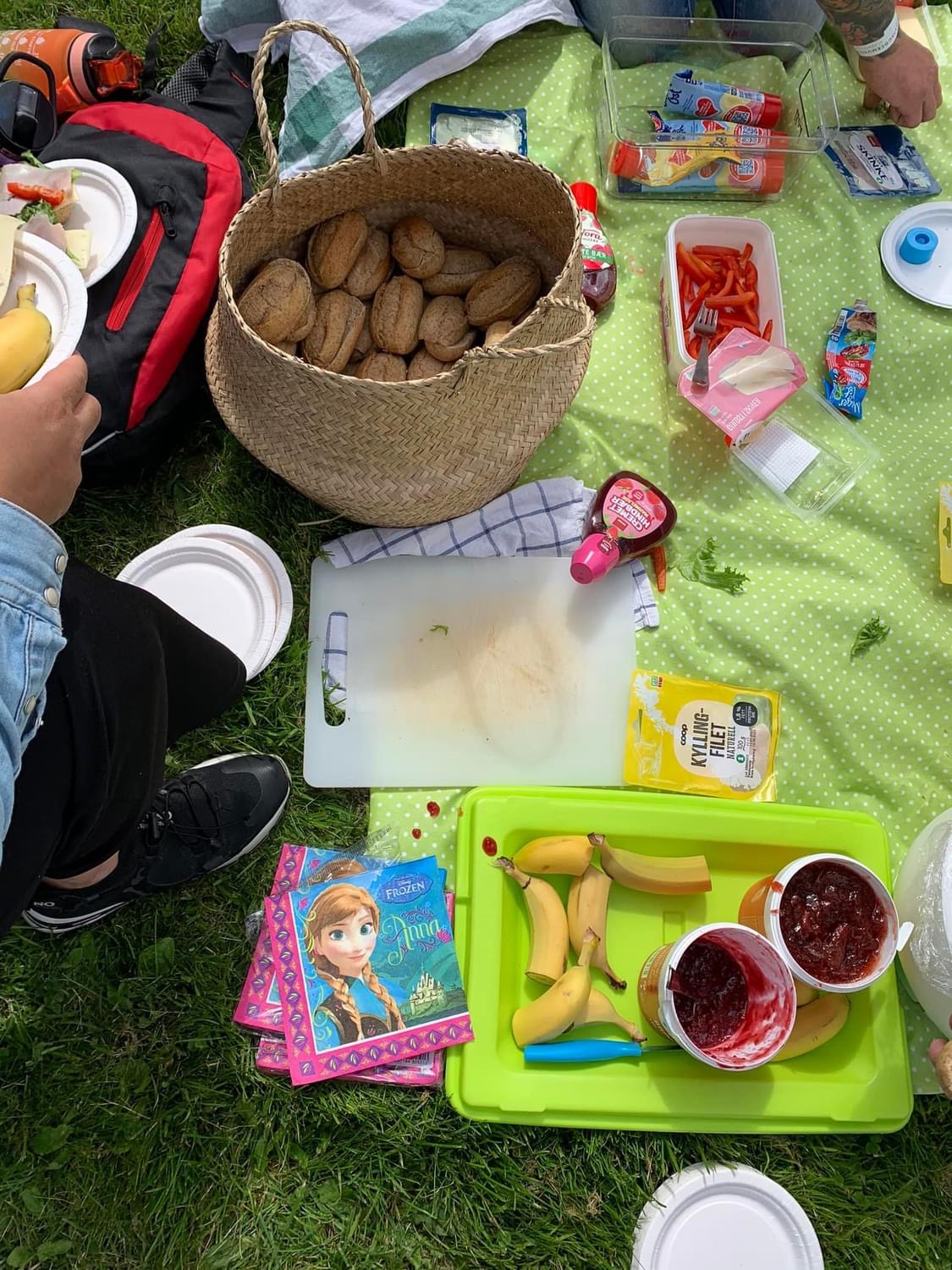 en piknikmatte fylt av mat for barn og voksne